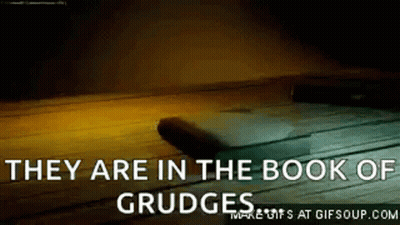 They Are In The Book Of Grudge Written On A Wooden Surface . GIF