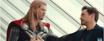 Thor And Iron Man Are Standing Next To Each Other In A Room . GIF