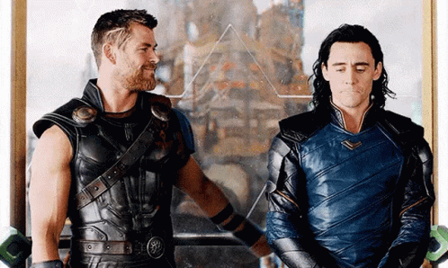 Thor And Loki Are Standing Next To Each Other In Front Of A Mirror In A Room . GIF