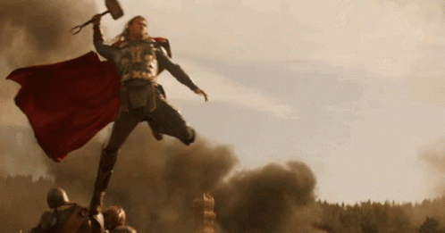 Thor Is Holding A Hammer In His Hand And Jumping In The Air . GIF