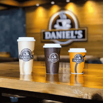 Three Daniel's Coffee Cups In Front Of Daniel's Sign GIF