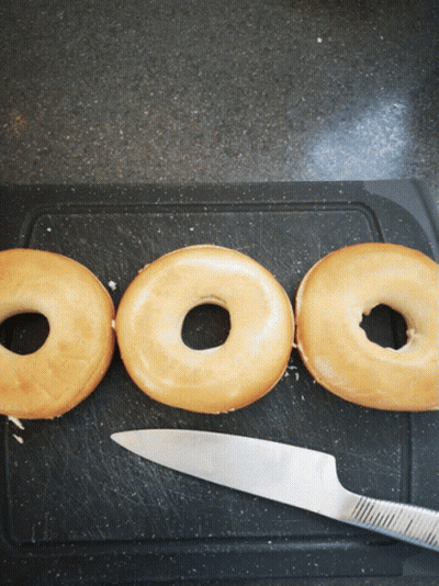 Three Donuts On Cutting Board With Knife GIF