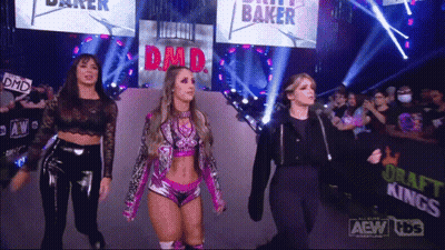 Three Female Wrestlers Are Walking Down The Aisle At A Wrestling Show GIF