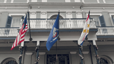 Three Flags On A Balcony Including One That Says Louisiana On It GIF