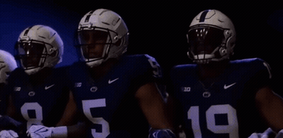Three Football Players Standing In Dark Room GIF