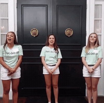 Three Girls Wearing Shirts That Say Alpha Delta Pi Stand In Front Of A Black Door GIF