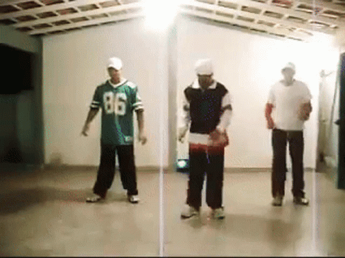 Three Men Are Dancing In A Room With One Wearing A Jersey With The Number 86 On It GIF