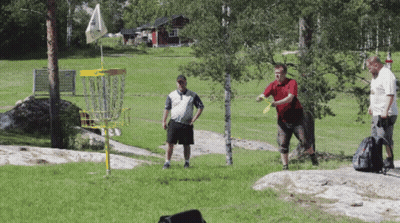 Three Men Are Playing Frisbee Golf In A Field With A Yellow Frisbee Basket GIF