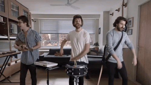 Three Men Are Playing Instruments In A Living Room GIF