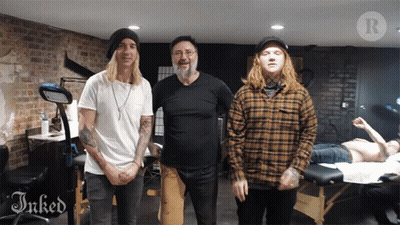 Three Men Are Posing For A Picture In A Room With The Word Inked On The Bottom GIF