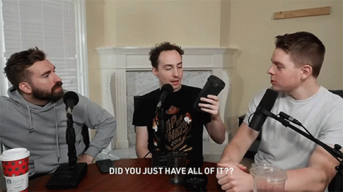 Three Men Are Sitting At A Table With Microphones And One Of Them Is Wearing A Shirt That Says Ipa Hints GIF
