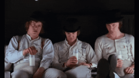 Three Men Are Sitting In A Dark Room Drinking Milk From Glasses GIF