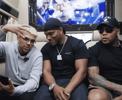 Three Men Are Sitting In Front Of A Tv And One Has A Hat That Says U.n.d.f. GIF