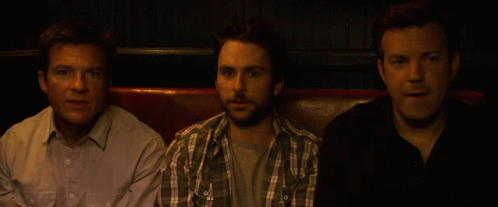 Three Men Are Sitting Next To Each Other On A Couch GIF