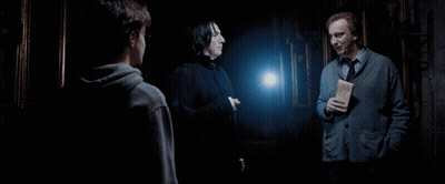 Three Men Are Standing In A Dark Room And One Of Them Is Holding A Letter GIF