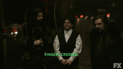Three Men Are Standing In A Dark Room With The Words Fingers Crossed In Green Letters GIF