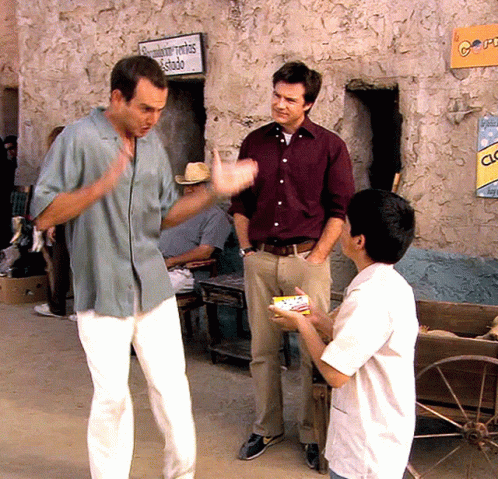 Three Men Are Standing In Front Of A Building With A Sign On It That Says Clock GIF