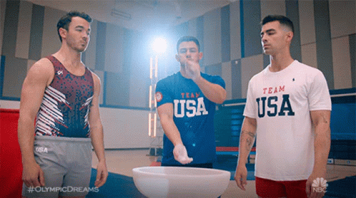 Three Men Are Standing Next To Each Other And One Of Them Is Wearing A Shirt That Says Team Usa GIF
