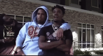 Three Men Are Standing Next To Each Other In Front Of A Building . GIF