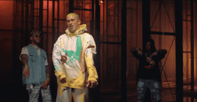 Three Men Are Standing Next To Each Other In Front Of A Building . One Of The Men Is Wearing A Yellow Hoodie . GIF
