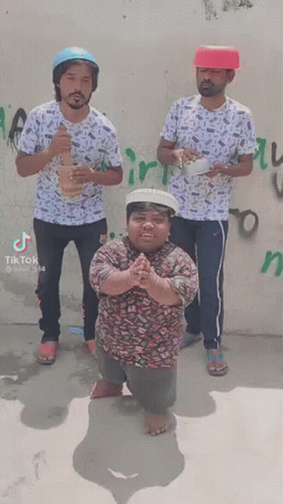 Three Men Are Standing Next To Each Other In Front Of A Wall . One Of The Men Is Wearing A Red Hat . GIF