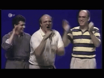 Three Men Are Standing Next To Each Other On A Stage Applauding And Smiling . GIF
