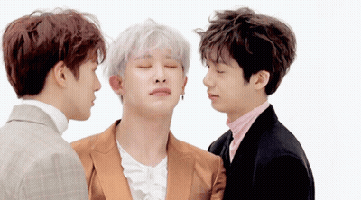 Three Men Are Standing Next To Each Other With Their Eyes Closed And One Of Them Is Wearing A Suit GIF