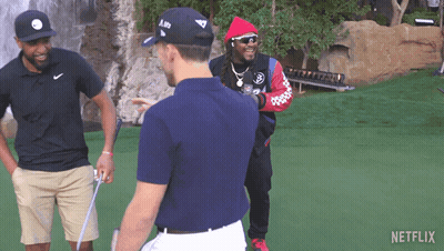Three Men Are Standing On A Golf Course And One Of Them Is Wearing A Hat With The Letter A On It GIF