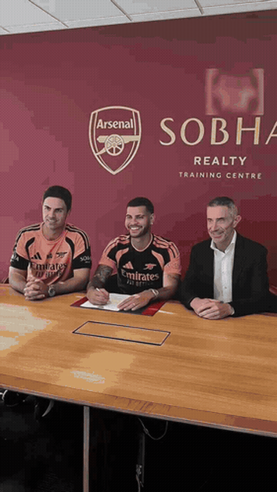 Three Men At Table In Front Of Sobha Realty Training Centre Sign GIF