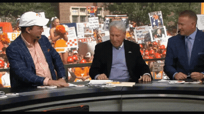 Three Men At Table With Cheerleader And Spike Sign GIF