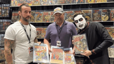 Three Men Holding Comic Books GIF
