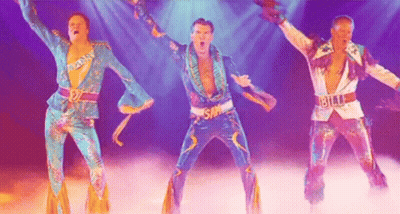 Three Men In Colorful Costumes Are Dancing On A Stage In Front Of A Purple Background . GIF