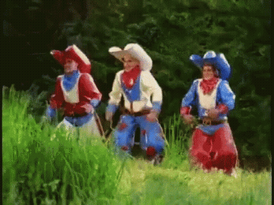 Three Men In Cowboy Costumes Standing In Field GIF