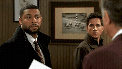 Three Men In Front Of Framed Picture Of Horses On Track GIF
