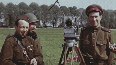 Three Men in Military Uniforms in a Field With Camera