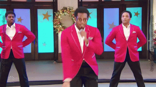 Three Men In Red Jackets Are Dancing In Front Of A Sign That Says Snbc GIF