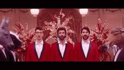 Three Men In Red Suits Are Standing Next To Each Other In Front Of A Fake Horse Head . GIF