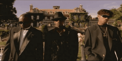 Three Men In Suits And Hats Are Standing In Front Of A Large House GIF