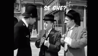 Three Men In Suits And Hats Are Standing Next To Each Other On A Street Talking To Each Other . GIF