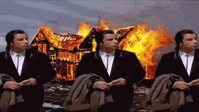Three Men In Suits Are Sitting In Front Of A Burning House . GIF