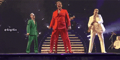 Three Men In Suits Are Standing On A Stage . GIF