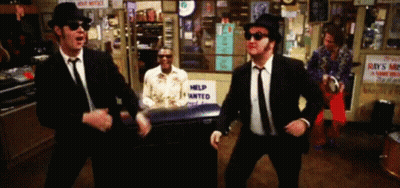Three Men In Suits Dancing In Front Of Help Wanted Sign GIF