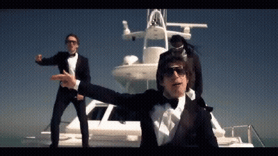 Three Men In Tuxedos Are Standing On A Boat GIF