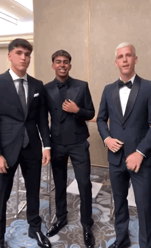 Three Men In Tuxedos Pose For Picture GIF