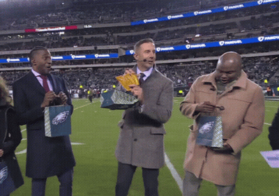 Three Men On Football Field Holding Eagles Bags GIF