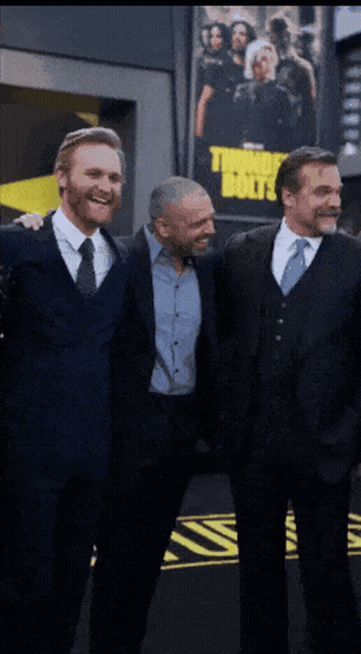 Three Men Posing In Front Of Thor's Boys Poster GIF