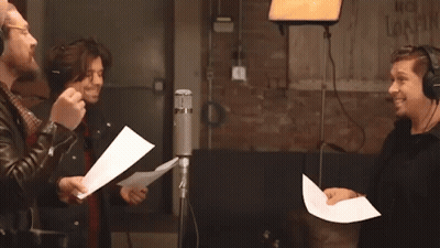 Three Men Singing Into Microphones With No Smoking Sign GIF