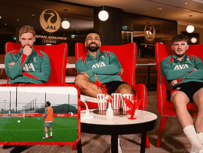 Three Men Sit In Red Chairs In Front Of A Japan Airlines Lounge Sign GIF