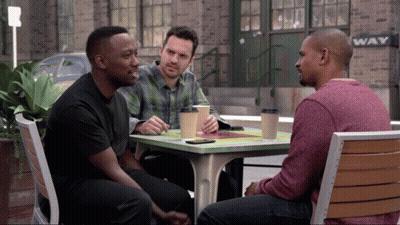 Three Men Sitting At Table In Front Of Wave Sign GIF