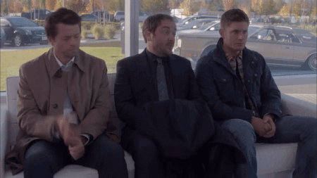 Three Men Sitting On Couch In Front Of Window With Cars GIF